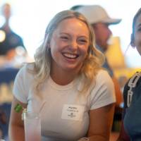 Two women smiling at someone they are talking to